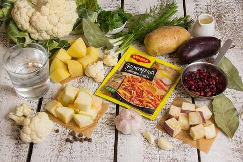  
1.

Картофель, кабачок и баклажан очистить и нарезать крупными кубиками. Цветную капусту разобрать на соцветия. Фасоль сварить и слить отвар. Чеснок пропустить через пресс. Укроп, зеленый лук и базилик мелко нарезать.
