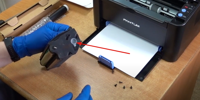 Если у вас заправленный картридж, будьте аккуратны с пробкой, указанной стрелкой. Потому что при съеме боковой крышки из нее может посыпаться тонер