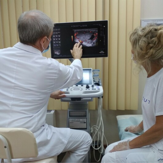 УЗИ щитовидной железы. Доктор Ушаков показывает пациентке кровоток узла в режиме ЭДК. 