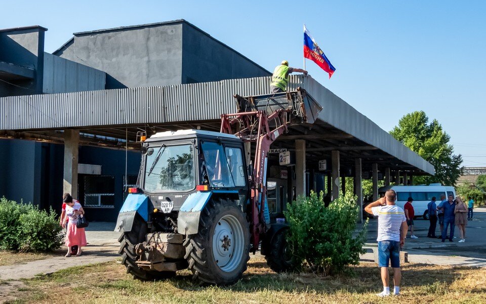     Запорожская область, Мелитополь. Установка российского флага на автовокзале, куда прибыл автобус, следующий по маршруту "Бердянск - Симферополь". Фото: Алексей Коновалов/ТАСС