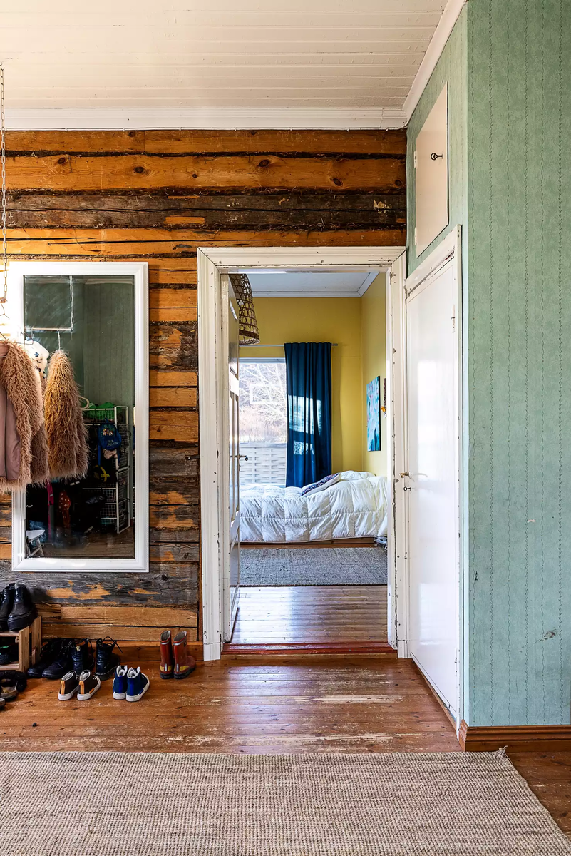 Площадь прихожей — 15 квадратов. На момент переезда семьи старая бревенчатая стена была в очень хорошем состоянии, поэтому ее не стали трогать