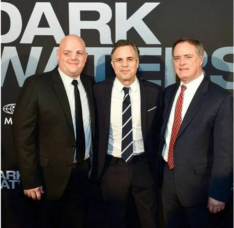 Слева направо: Баки Бейли родившийся с деформациями лица из-за работы матери в Дюпон во время беременности, сыграл самого себя в эпизодической роли в фильме "Темные воды"; Марк Руффало сыгравший Роберта Билотта - "адвоката ставшего кошмаром для Дюпон"; непосредственно Роберт Биллотт.