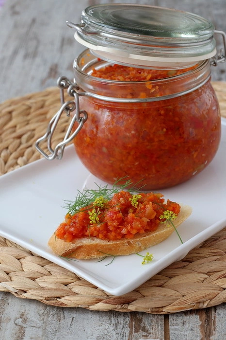 Этому рецепту уже много лет, я его знаю еще со школьных времен, когда только начинала готовить самостоятельно. Одно время готовила эту икру часто, но потом рецепт забылся, и вот обнаружила его в своей старинной тетрадке и захотелось приготовить.

Эту икру можно готовить не только впрок, но и в любое время, когда захочется. Зимой можно заменить свежие помидоры томатом, а сладкий перец вообще исключить из рецепта.

ПОНАДОБИТСЯ:

- 1 кг моркови
- 2 кг помидоров
- 500 г сладкого перца
- 1 головка чеснока
- 2 острых перца
- 150 г сахара
- 1,5 ст.л. соли
- 1 ч.л. кориандра или тмина
- 2 лавровых листа
- 100 г 9% уксуса
- 200 г раст.масла

В те давние-давние времена)) морковь я натирала на крупной терке, перец резала мелкими кубиками, а помидоры пропускала через мясорубку. Сейчас все эти действия я доверяю кухонному комбайну, а каким образом вы измельчите продукты - только ваш выбор.
Итак, измельченные овощи сложить в толстостенную посуду (жаровня отлично для этого подойдет), добавить соль, сахар, молотые специи и растительное масло. Довести смесь до кипения и тушить 2,5 часа на небольшом огне.
Добавить измельченный чеснок, мелконарубленный перец, лавровый лист. Готовить еще 10 минут, добавить уксус, размешать, разложить по стерильным банкам, закрыть крышками.