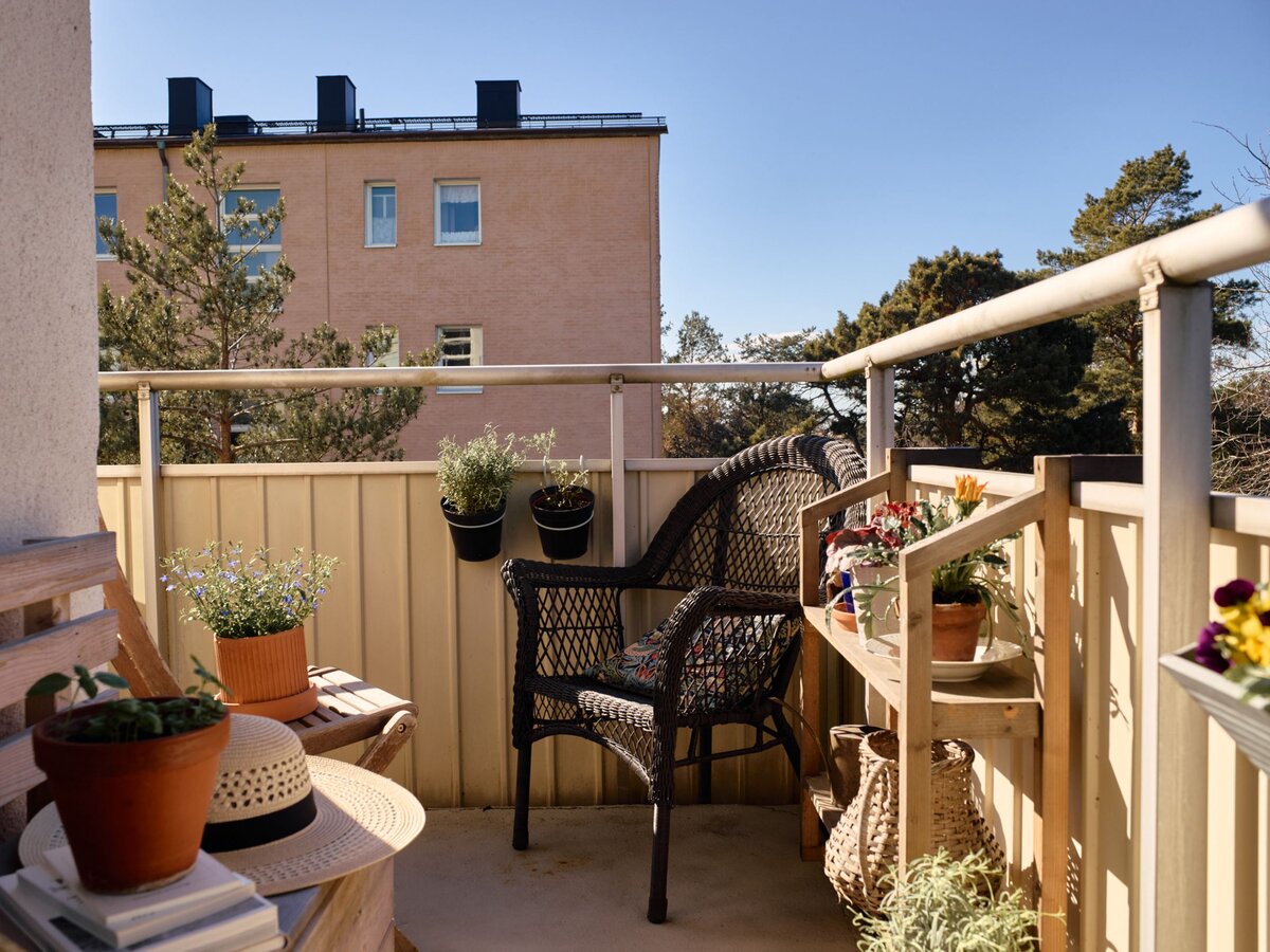 Квартира располагается на последнем этаже. На угловом балкончике довольно уютно — много цветов, несколько стульев для отдыха, которые не видны с улицы