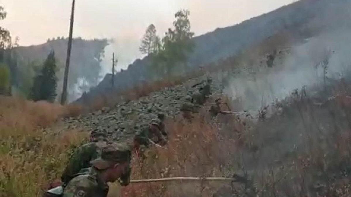    Люди тушат траву, горящую на склоне холма:пресс-служба ДЧС ВКО