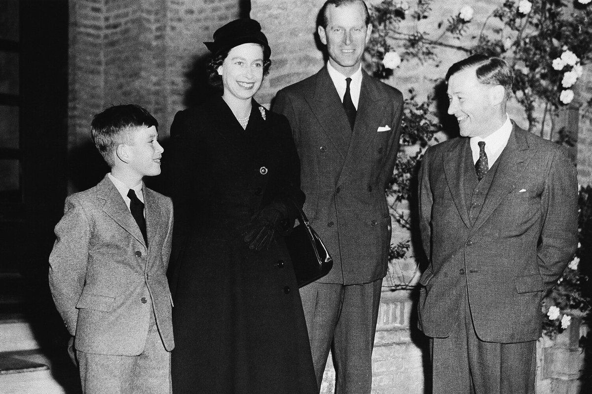 Принц Чарльз (слева), Елизавета II и принц Филипп с директором школы Cheam School Питером Беком, где учился принц Чарльз, 1957 год 
Фото:  AP
