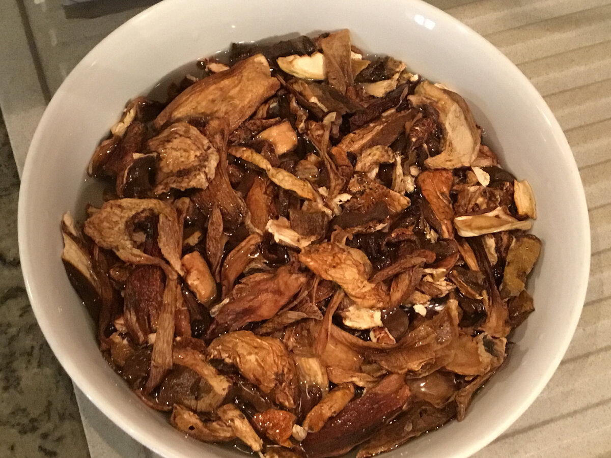 Как всегда, грибы сначала нужно замочить на час-полтора. Затем отжать грибы и вылить воду. Опять залить грибы водой на час-полтора. 