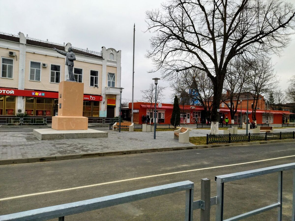 Справа на фото, по аллейке за Ленином, вдалеке на лавочке сидят бабульки с первого снимка. А город пустой.