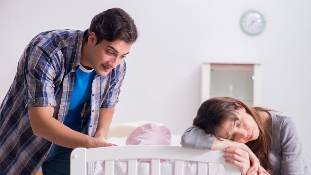 Ребенок возле кровати. Мужчина смотрит на своего ребенка в кроватке. Печаль родители возле кроватке без ребёнка. Многодетная семья вокруг кроватки с новорожденным фото.