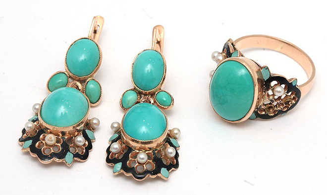 Гарнитур из золота с природной бирюзой, состоящий из кольца и сережек, украшенный горячей эмалью и мелкими белыми жемчужинами. Кабашоны из натуральной бирюзы оправлены в гладкие касты с мелкой насечкой по краю. Две жемчужинки на кольце утрачены. Предположительно Россия, третья четверть XX в.
