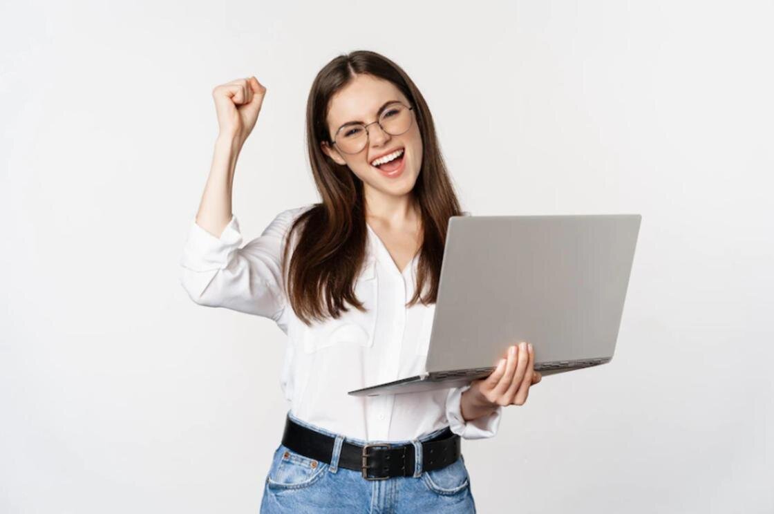    Радостная девушка с ноутбуком в руках:Freepik