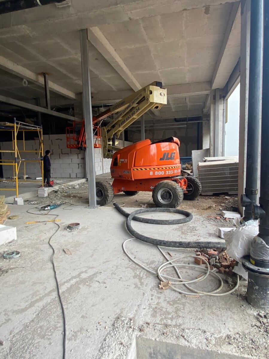 Коленчатый подъемник JLG 450 AJ из арендного флота VERTEX помогает монтировать системы вентиляции в строящемся ТРЦ г. Москвы