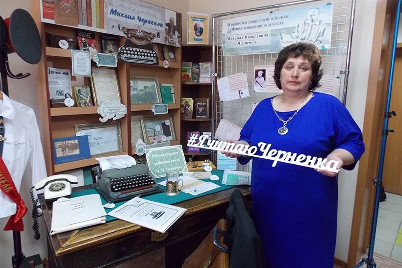 Заведующая отделом краеведения Тогучинской библиотеки Татьяна Паунова у рабочего стола писателя Михаила Черненка.