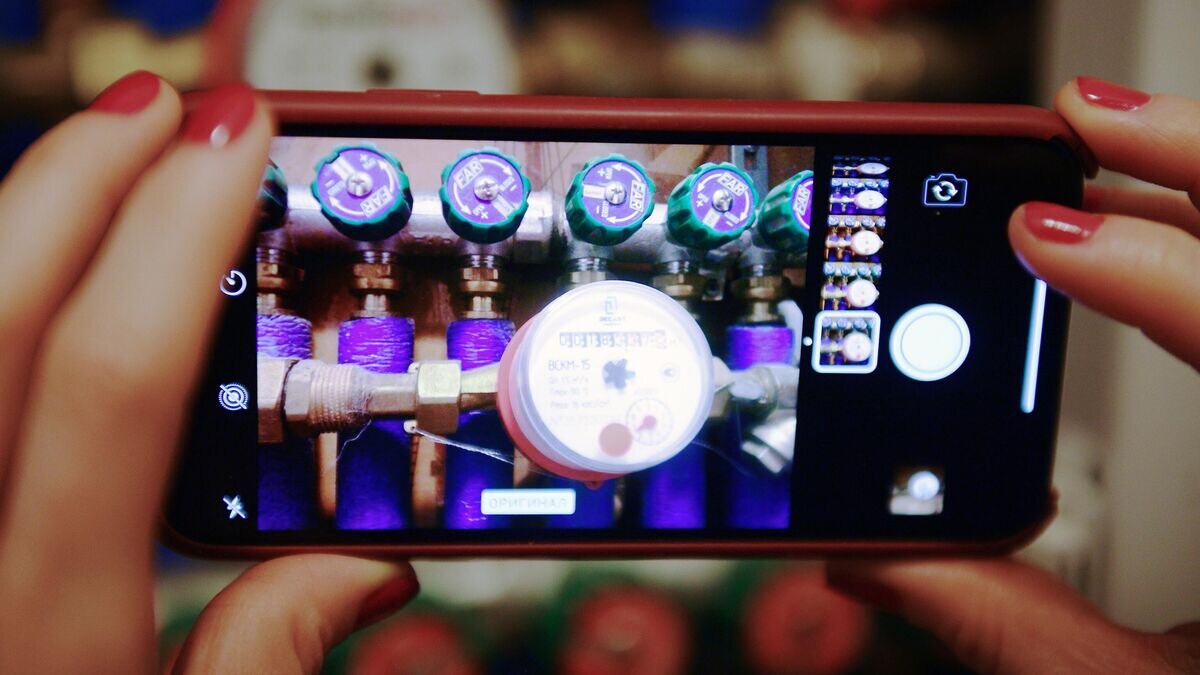    Счетчик учета горячей воды на экране смартфона© РИА Новости / Евгений Одиноков