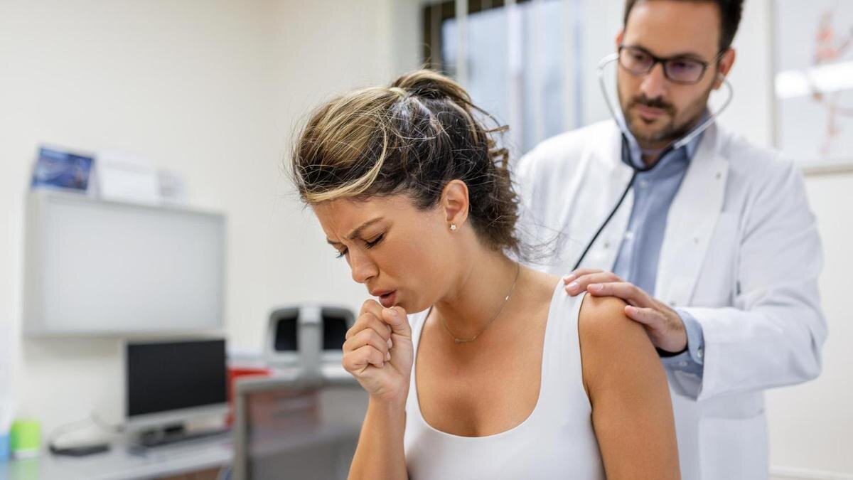    Кашляющую женщину обследует доктор:Freepik