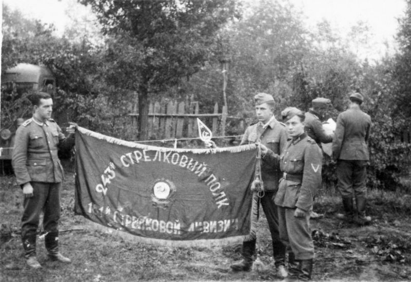 Немецкие солдаты позируют с захваченным знаменем советского 243-го стрелкового полка 181-й стрелковой дивизии. 