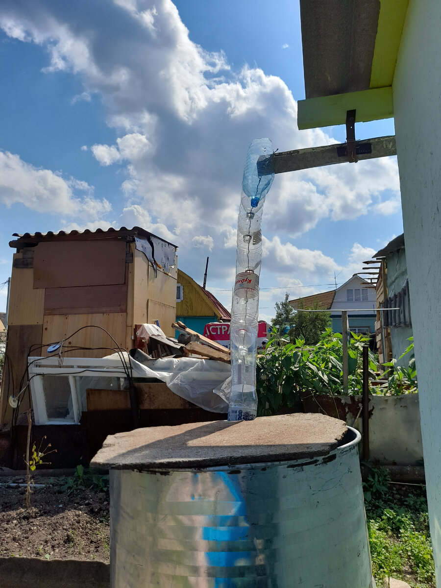 Вот такую систему соорудил мой муж, чтоб дождь с крыши стекал в бочку. Фото автора.