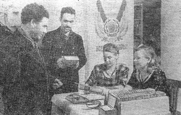 Библиотека завкома Тихвинского глинозёмного завода (ТГЗ). На фото (слева направо): К.Светлов и Г.Виноградов. Библиотекари: В.Чумакова, Т.Садкова. Фото из газеты "Знамя коммунизма", автор - В.Кадобнов.
