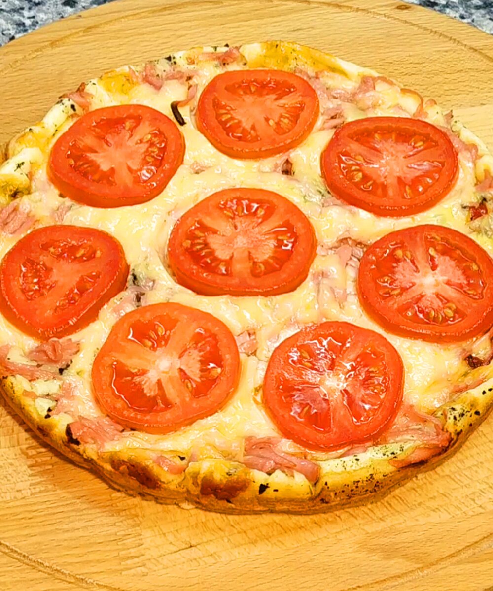 Нежная и очень вкусная пицца на сметане. 
Ингредиенты для формы Ø24 см.:
Для теста:
яйцо - 2 шт.
соль - 0.5 ч.л.
сметана 18% -180 гр.
мука - 100 гр.
сливочное масло для смазки формы - 20 гр.
Для начинки:
кетчуп - 2 ст.л.
базилик сушеный или прованские травы по вкусу
колбаса вареная - 100 гр.
сыр - 80 гр.
помидоры - 140 гр.
соль для помидоров по вкусу

1. Разогреть духовку до 200 градусов.
2. Яйца взбить с солью. Добавить сметану, перемешать.
3. Всыпать муку, перемешать.
4. Форму Ø24 см. смазать сливочным маслом. Влить приготовленное тесто, распределить.
5. На тесто выложить небольшими порциями кетчуп. Сверху посыпать базиликом.
6. Колбасу натереть на крупной терке, выложить сверху.
7. Сыр натереть на крупной терке, выложить на колбасу.
8. Помидор нарезать кольцами, выложить на сыр, присолить по вкусу.
9. Выпекать в разогретой до 200 градусов духовке 20-25 минут.