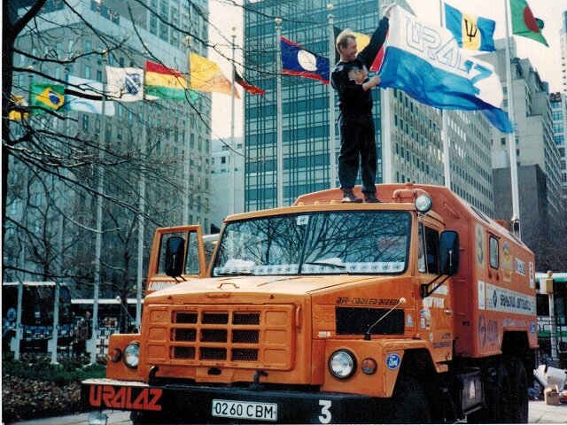 Апрель 1994 года, Нью-Йорк. Участник автопробега "Лондон — Нью-Йорк: по суше" Владимир Глебов с флагом УралАЗа у здания ООН      