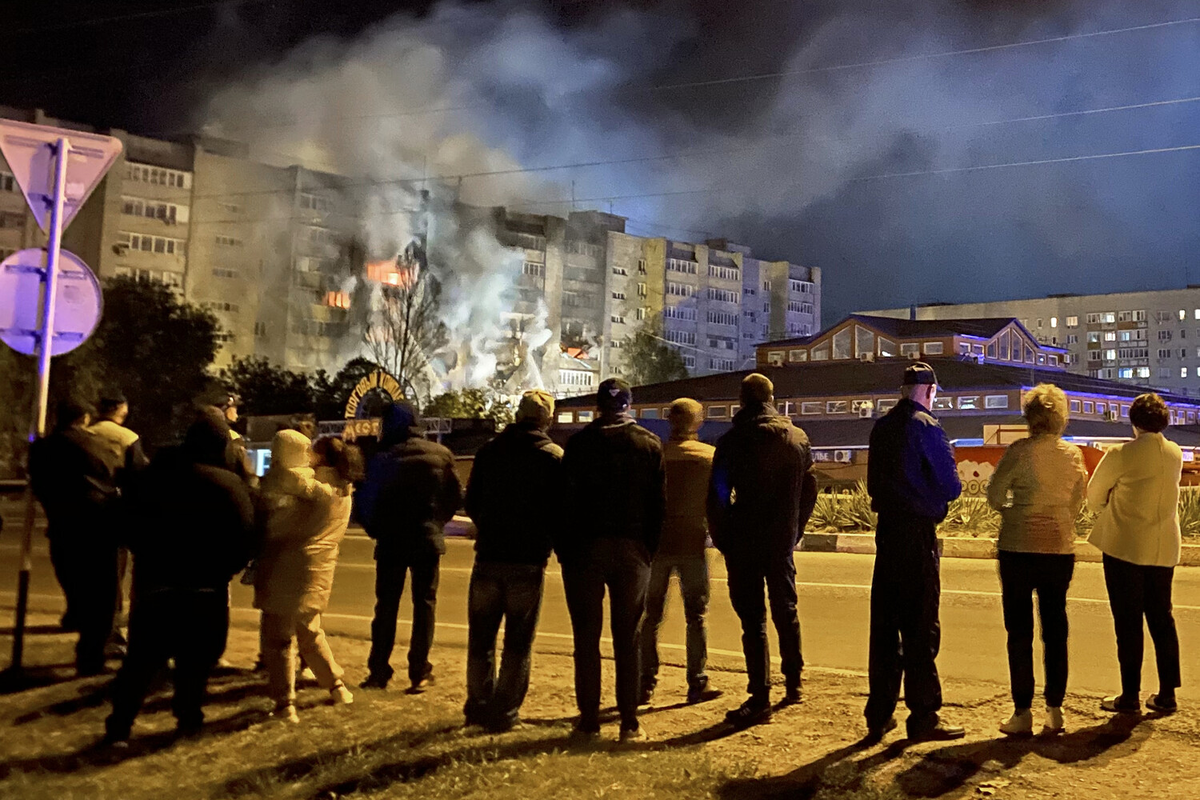 Очевидцы наблюдают за пожаром в жилом доме после падения истребителя-бомбардировщика Су-34 в Ейске, 17 октября 2022 года 
Фото: РИА «Новости»