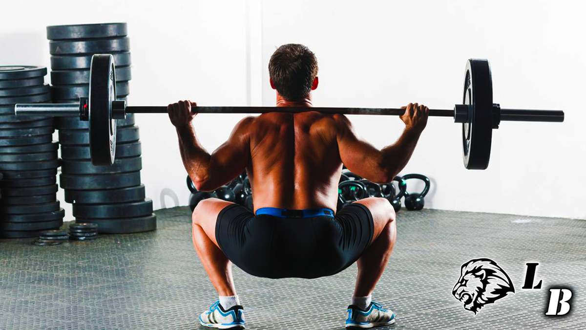 Со штангой. Barbell back Squat. Мужчина приседает со штангой. Приседания со штангой в тренажёрном зале мужчина. Мужчины занимаются в зале со штангой.