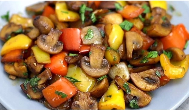 Шампиньоны – 300 грамм 
Лук – 1 штука 
Сладкий желтый перец – 1/2 штуки 
Сладкий красный перец – 1/2 штуки 
Перец острый – 1/2 штуки (по желанию) 
Чеснок – 1 зубчик 
Петрушка 
Для соуса:
Коричневый сахар – 1 чайная ложка 
Соевый соус – 2 столовые ложки 
Рисовый уксус – 1 столовая ложка 
Кетчуп – 1 столовая ложка

Грибы нарезаем на небольшие кусочки и обжариваем на растительном масле. 
 
Добавляем к грибам лук нарезанный на кусочки среднего размера, сладкие перцы, нарезанные на куски среднего размера, острый перец мелко нарезанный и всё перемешиваем. 
 
В небольшую мисочку насыпаем коричневый сахар, вливаем соевый соус, рисовый уксус, кетчуп и размешиваем. 
 
Овощи на сковороде солим, перчим, добавляем измельчённый чеснок, вливаем подготовленный соус и перемешиваем. 
 
Добавляем измельчённую петрушку, перемешиваем и подаём к столу!