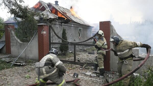    Сотрудники МЧС ДНР во время тушения пожара, возникшего в результате обстрела со стороны ВСУ Киевского района Донецка© РИА Новости / Константин Михальчевский