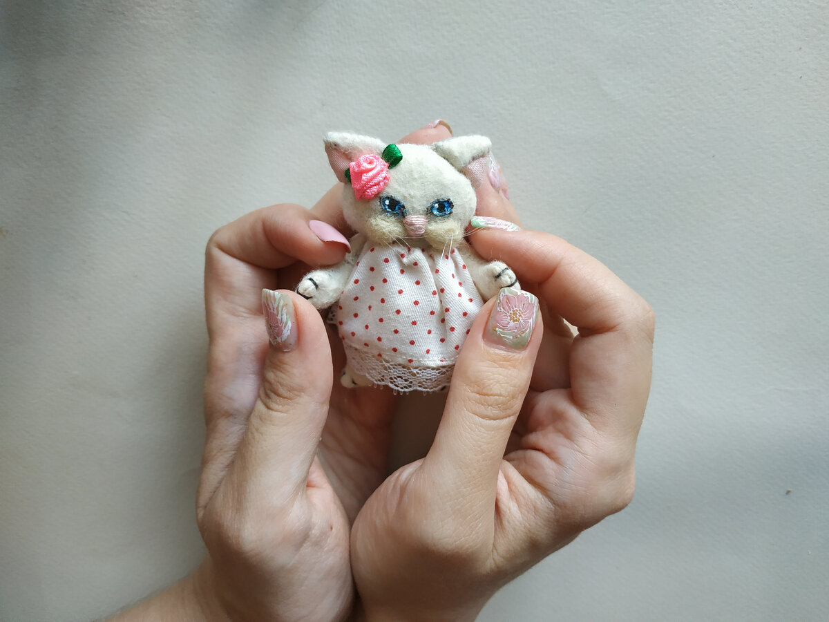 Я держу её в ладонях, чтобы был виден её размер. На ней платьице в горошек. Нормальный горошек для неё по размеру? Мне кажется, да. Фото из архива автора.