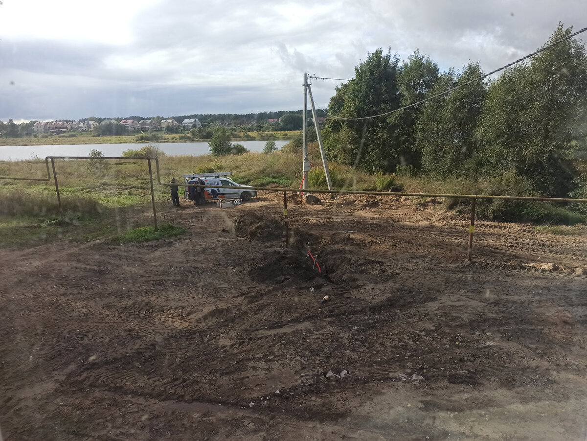 В незакоппнном участке траншеи виднеется красная гофра