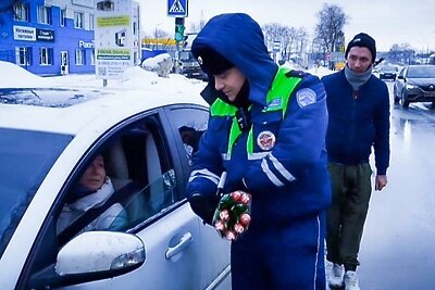    Сотрудник ГИБДД в Бронницах дарит цветы женщине на 8 марта ©Ольга Антонова Фото