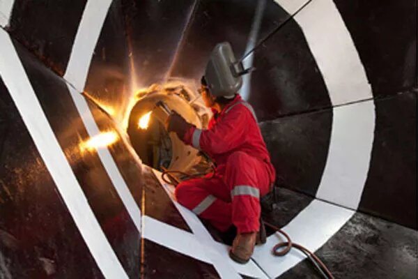 Сварщик работает над так называемым возвратным конусом, который используется для направления бурильной трубы на дно океана. (Изображение предоставлено IODP) 