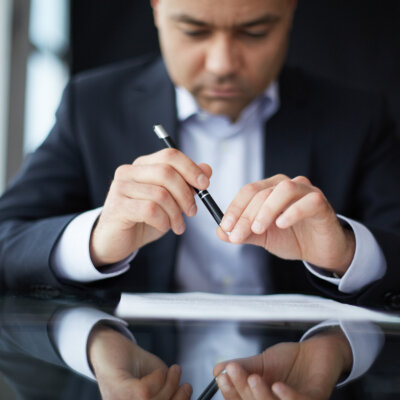    Close-up of male hands with pen over document Валерий