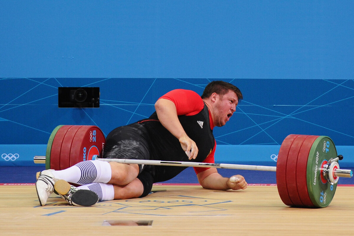 Спортсмен поднимает штангу