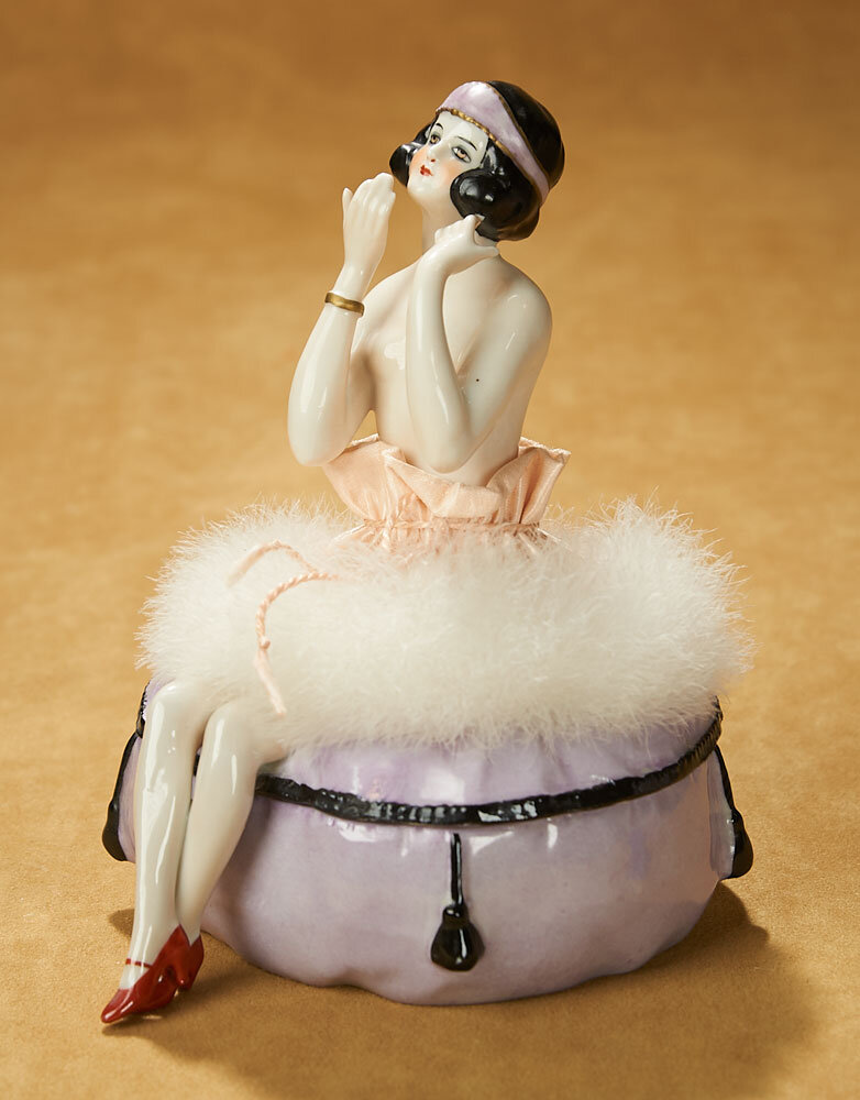 Фарфоровая половинка куклы и фарфоровые ножки. Так оформлена пуховка и пудреница. Германия, около 1920 г. Фото theriaults.com