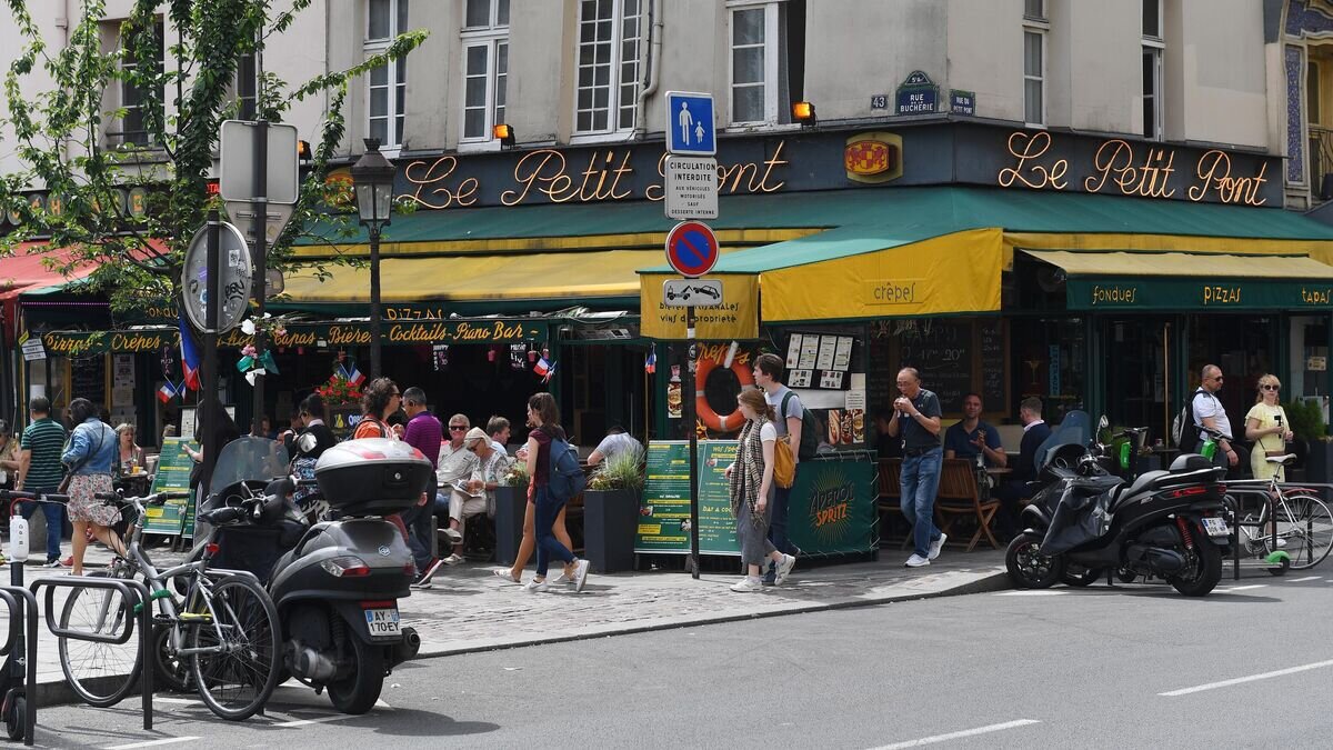    Горожане и туристы на улице Rue du Petit Pont рядом с пабом Cafe Le Petit Pont в Париже© РИА Новости / Сергей Мамонтов