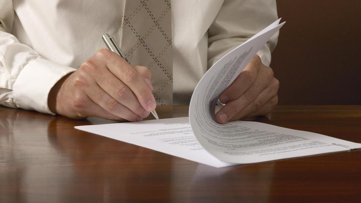    Мужчина подписывает документ:Richard Drury/Getty Images