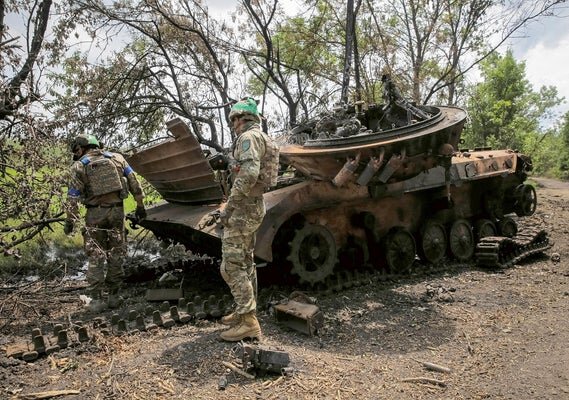 14 июня украинские солдаты возле недавно захваченной деревни в Донецкой области, восточная Украина, осматривают уничтоженную российскую военную технику.