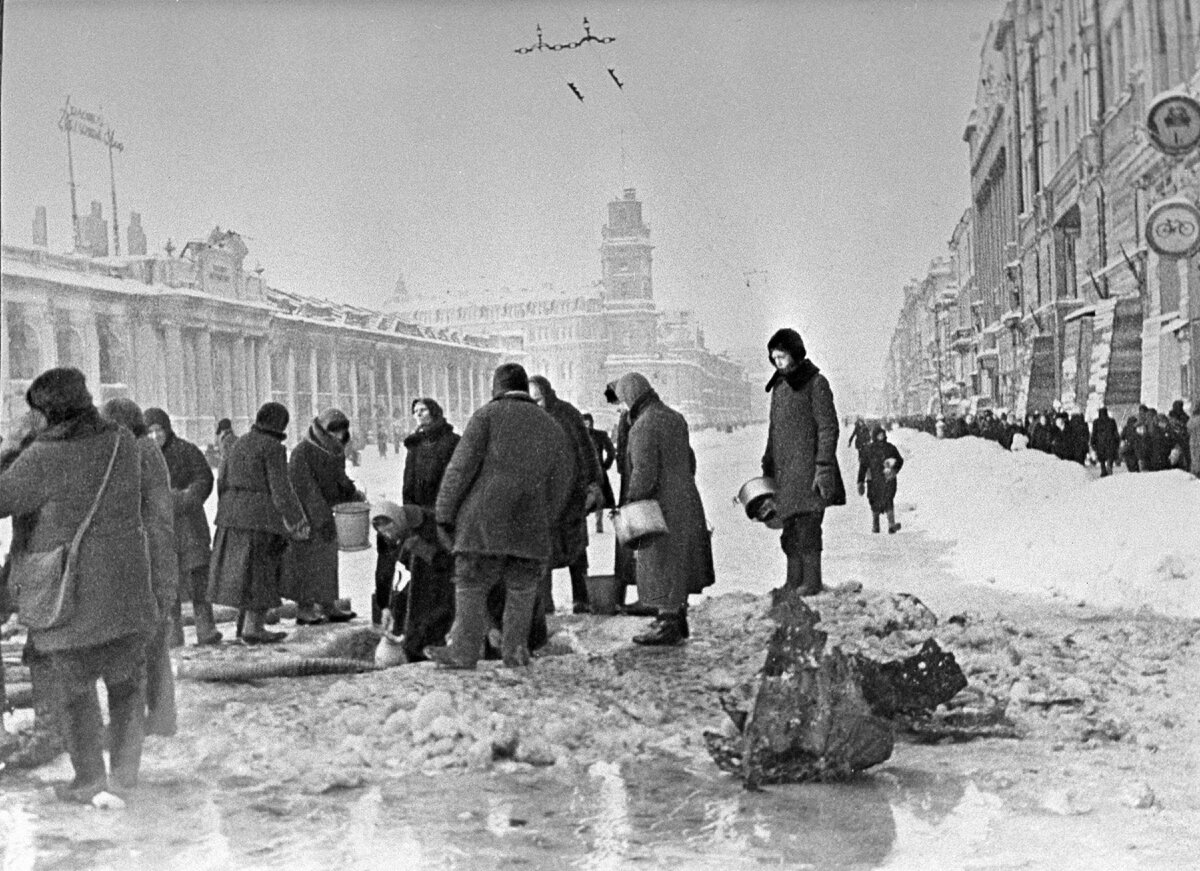 Жители блокадного Ленинграда набирают воду, появившуюся после артобстрела в пробоинах в асфальте. Автор Б. Кудояров.