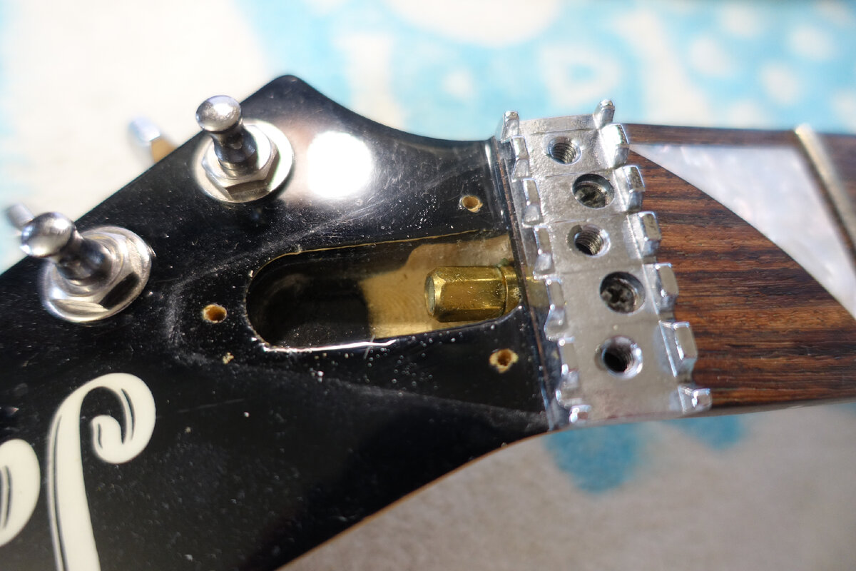 Гайка анкерного болта выполнена под накидной ключ. След от наклейки на пятке грифа нормально сфотографировать не получилось.