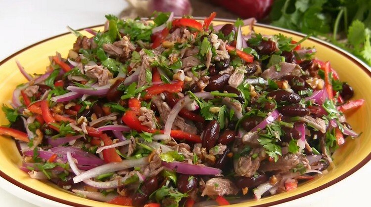Яркий, пикантный, сытный и невероятно вкусный салат "Тбилиси" с отварной говядиной и красной фасолью. Салат никого не оставит равнодушным, его вкус запоминается с первого раза. Настолько удачное сочетание компонентов, ароматная заправка, зелень и специи - все это гармонично складывается в одном блюде. Не стоит заменять или убирать какие-то ингредиенты, именно в этом салате все идеально, ничего лишнего. Обязательно добавляйте и острый перец, и кинзу, и грецкие орехи. Также позаботьтесь, чтобы салат не проиграл во вкусе из-за недостаточно нежного мяса, поэтому максимально долго варите говядину до готовности.