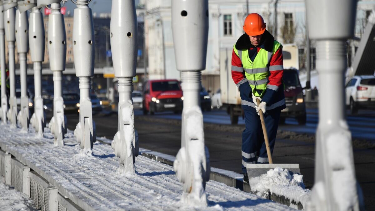    Сотрудник коммунальных служб чистит снег на Крымском мосту в Москве© РИА Новости / Евгений Биятов