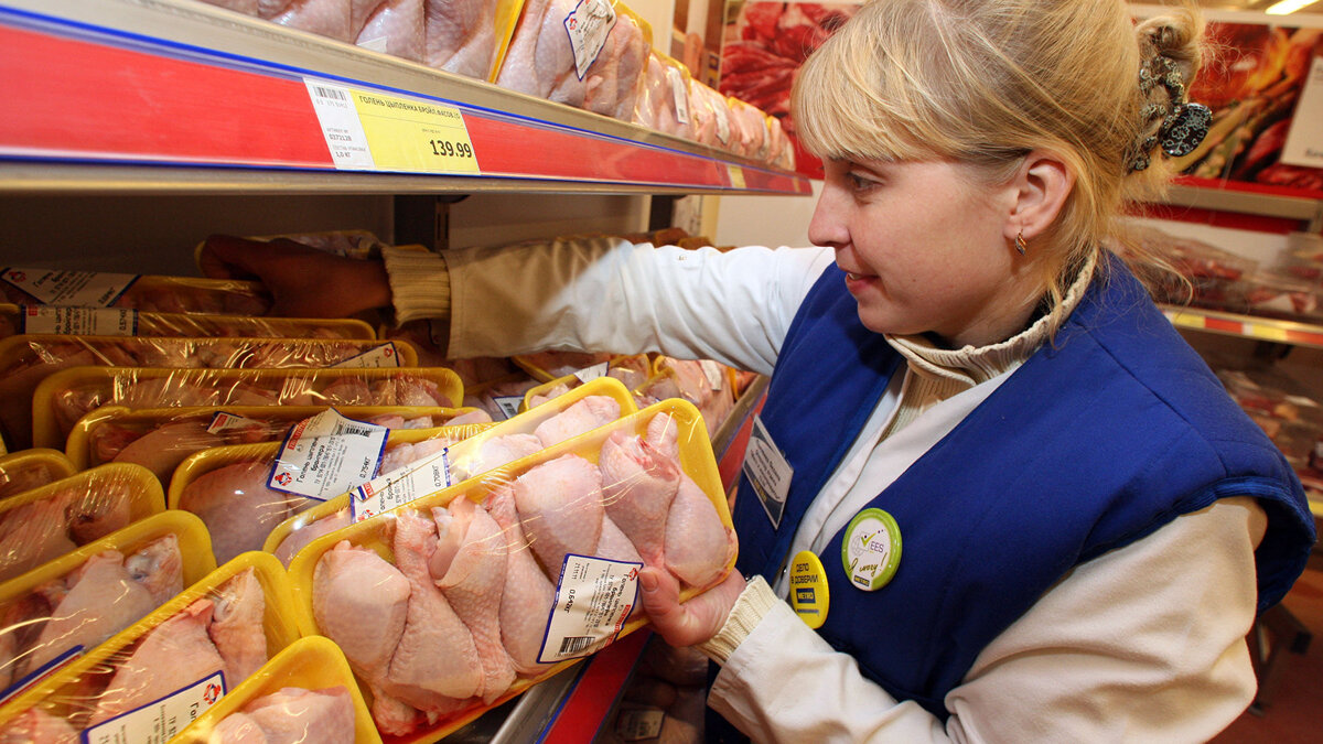    Упаковки мяса птицы раскладывают на полках© РИА Новости . Игорь Зарембо