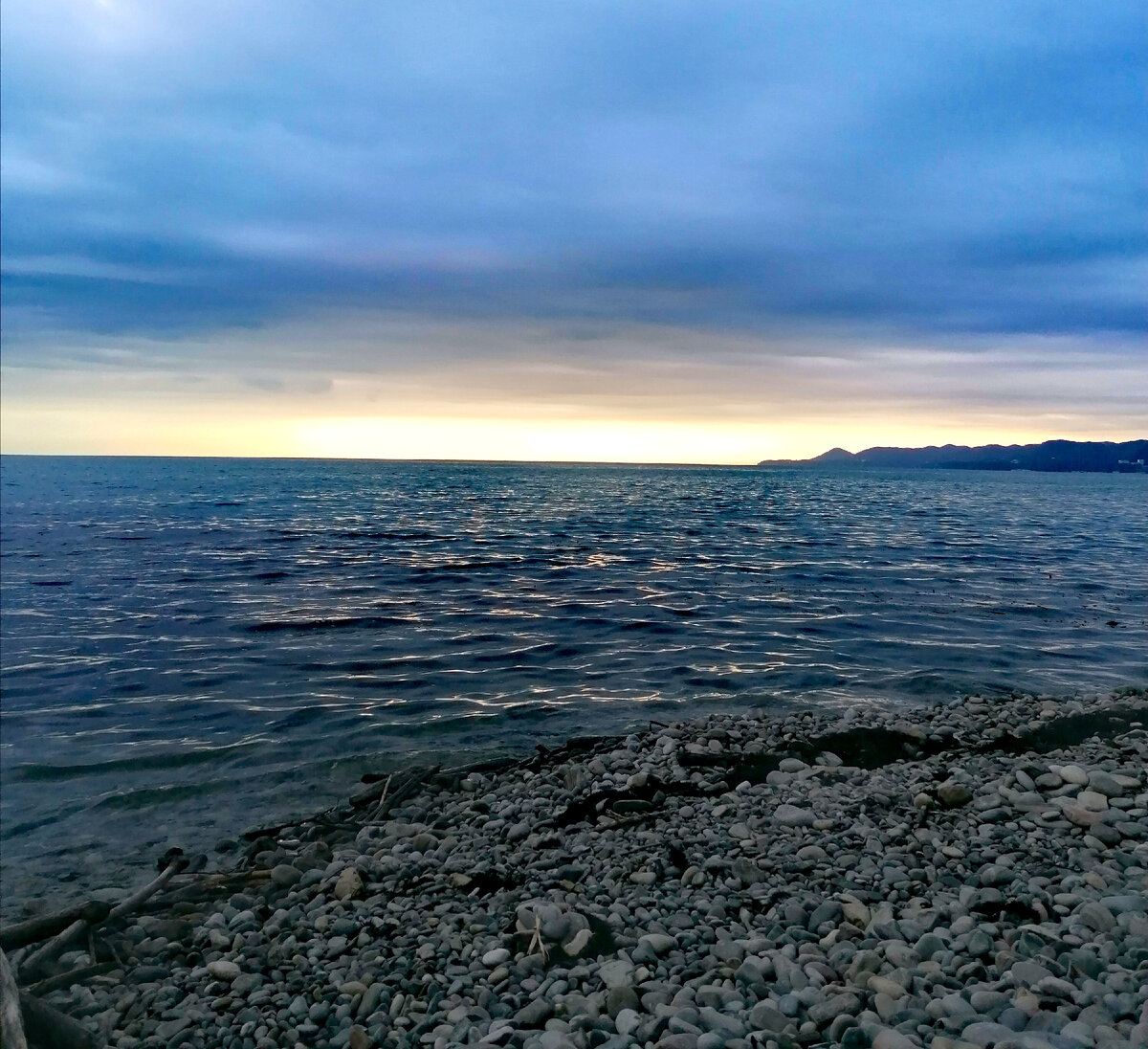 Пляж на закате возле скалы