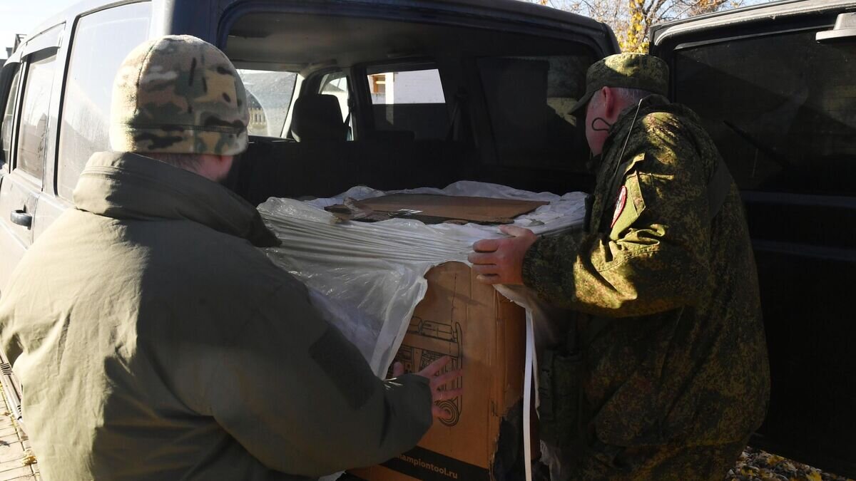    Военнослужащие ВС РФ разгружают гуманитарную помощь, привезенную журналистами РИА Новости, в Запорожской области© РИА Новости