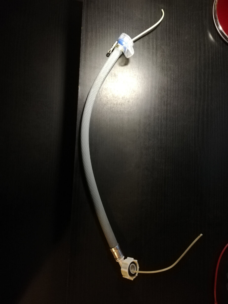 На второй конец обрезка шланга подсоединяем пробку от детской пластиковой бутылки с соском и зажимаем хомут.