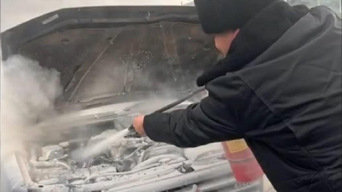    Полицейский тушит горящую машину:polisia.kz