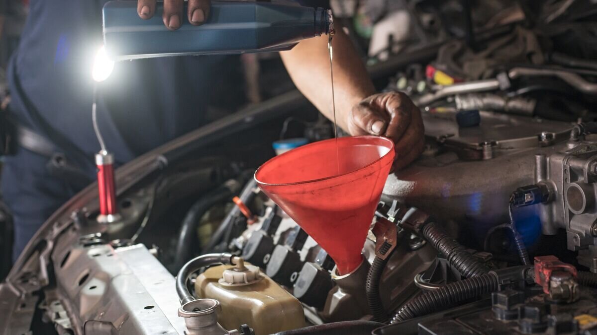    Мужчина заливает масло в двигатель автомобиля© Fotolia / Witthaya