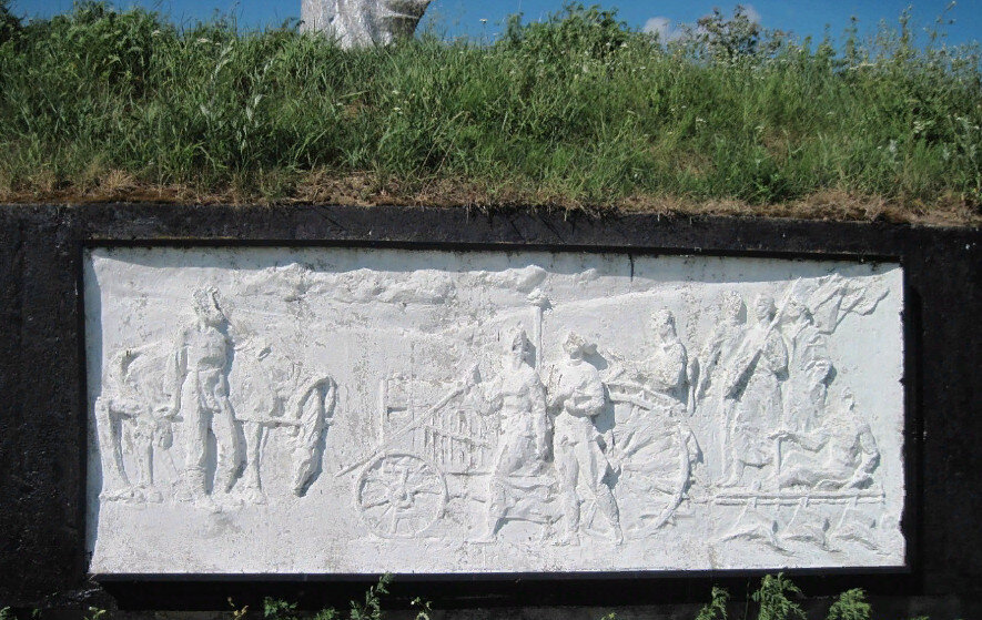 На одном из барельефов- гдовский трактор, такой же можно видеть в самом Гдове как монумент