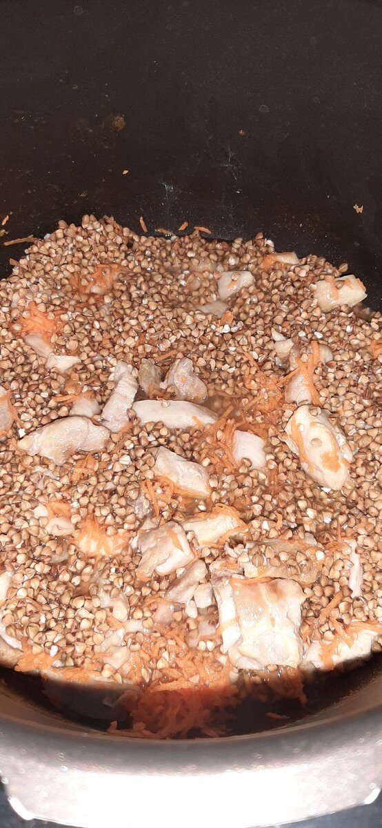 Мясо, морковь, гречка, специи и вода в чаше мультиварки. 